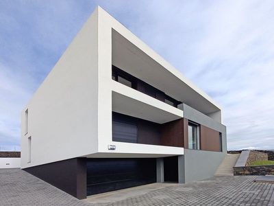 Num terreno com uma topografia complexa, foi criado um espaço exterior a nascente que permite uma relação privilegiada com as zonas de estar da moradia. Um muro de pedra ajuda a definir um patamar inferior onde se localiza o acesso à garagem.